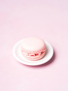 法国草莓玛卡龙在飞碟上空粉红色粉彩背景