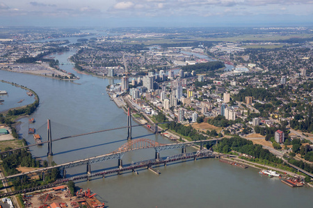 Pattullo 和轻轨大桥横跨弗雷泽河的鸟瞰城市景观。在加拿大不列颠哥伦比亚省的大温哥华拍摄