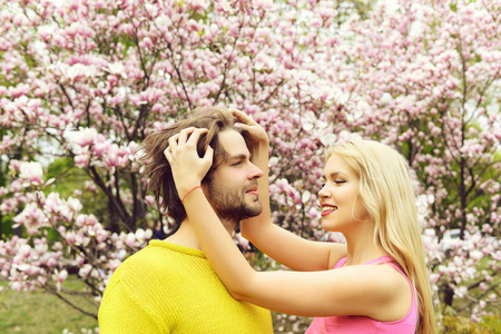 浪漫的情侣在春天盛开的玉兰花园中的爱