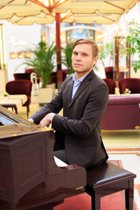 英俊的年轻男子在 restaurante 钢琴演奏