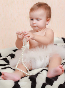 肖像新生的婴儿躺在床上与一条珍珠项链