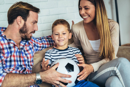 父亲和母亲给他们的儿子一个足球球