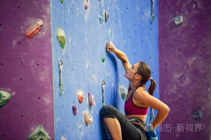 体育妇女的照片与滑石袋后面练习爬壁