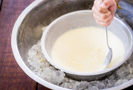 孩子们与冰碗自制的冰淇淋。旋转钢碗制作香草冰激淋