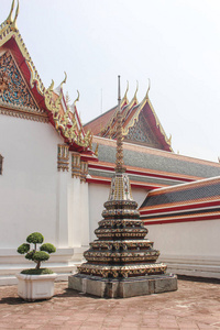 盆景树旁边的小佛塔以笏寺为背景。曼谷, 泰国