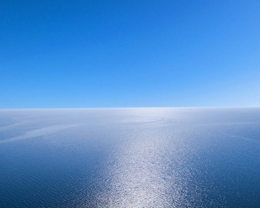 鸟瞰蓝海水背景和太阳反射.空中飞行无人机视图.