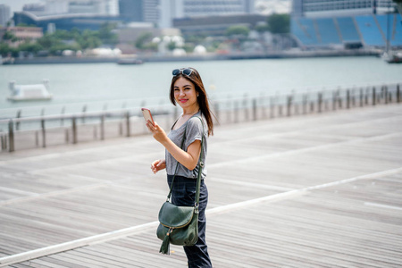 年轻漂亮的亚洲女人使用智能手机