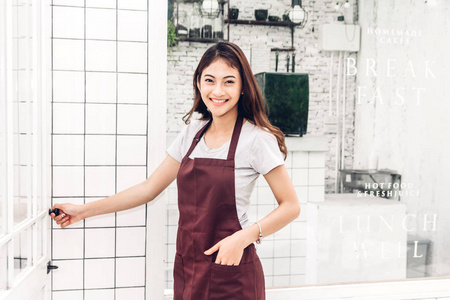 女小企业老板的肖像微笑着站在咖啡馆或咖啡馆外交叉的怀抱. 女咖啡店站在咖啡馆