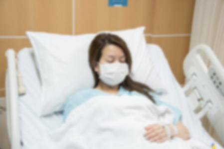 离焦模糊的照片的女人病在医院病房的床上
