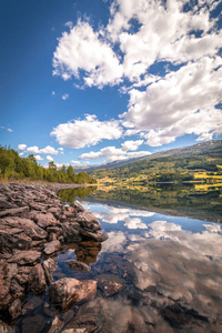 挪威山湖夏天风景。在清澈的水面上反射的云彩