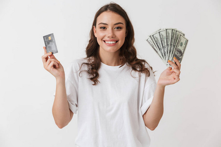 一个微笑的年轻的休闲黑发妇女的肖像持有信用卡和孤立的白色背景