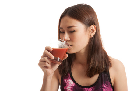 美丽健康的亚洲女孩喝番茄汁