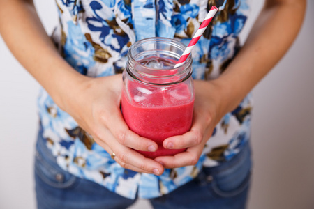 年轻女子拿着冰沙在玻璃罐排毒饮料照片