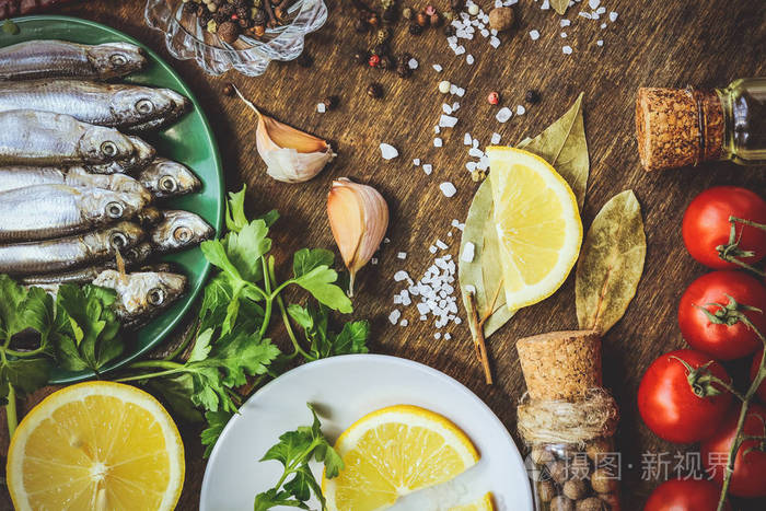 小鱼, 有香料, 柠檬, 西红柿和盐在木质背景下
