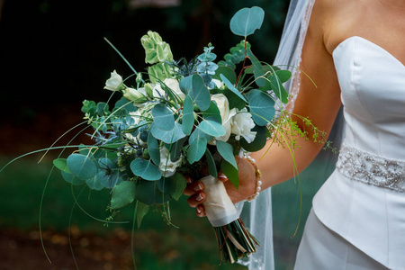 特写新娘玫瑰花束手捧着美丽的婚礼花束