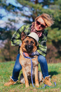 德国牧羊犬和漂亮女孩在森林里玩