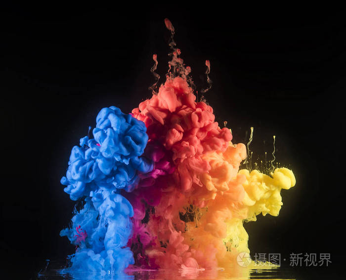 五颜六色的彩虹颜料从上面的水中混合而出.水下旋转墨水