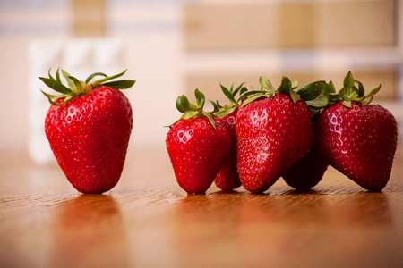 在木质表面上的熟草莓。水果背景
