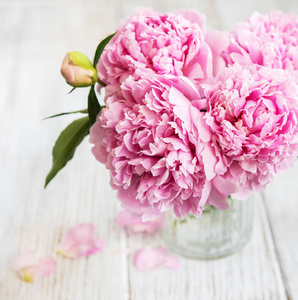 白色木桌上的粉红色牡丹花花瓶