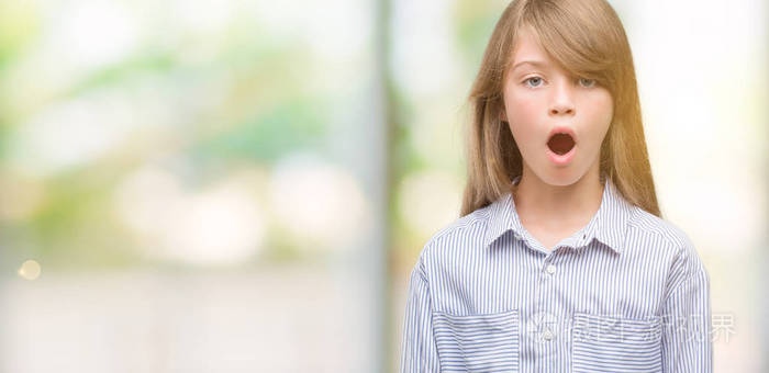 年轻的金发小宝宝穿着蓝色的衬衫吓坏了惊讶的脸害怕和兴奋的表情恐惧