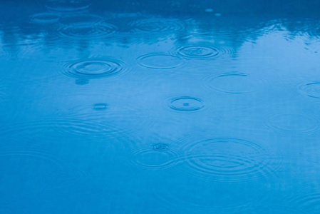 雨点落在水池或蓝湖上