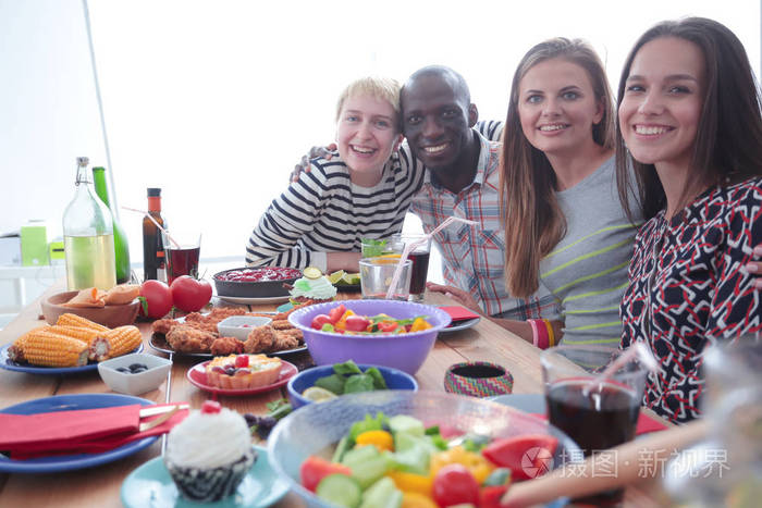 顶视图的一群人在一起时坐在木桌吃饭.在桌子上的食物.人们吃快餐