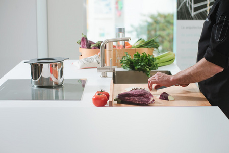 特写男人的手在厨房切菜照片
