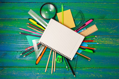 空白笔记本与学校供应在蓝色木头背景, 概念回到学校背景