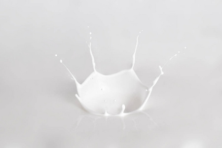 牛奶溅在白色背景上。飞溅的牛奶, 飞溅酸奶或化妆品奶油特写。模板为下落在牛奶莓果或一块果子