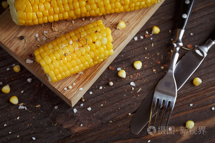 金灿灿的玉米棒子与油 香草和盐仿古木制的桌子上
