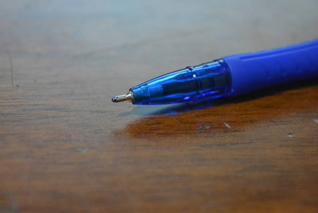 蓝色非常美丽的塑料圆珠笔在棕色漆木背景