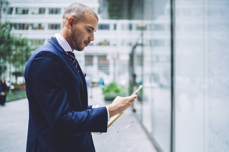 公司开工通知持有智能手机和阅读通知的金融公司成功拥有者的侧面视图