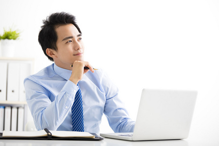 工作思考他的笔记本电脑上工作和思考的商人对着笔记本电脑思考的商务