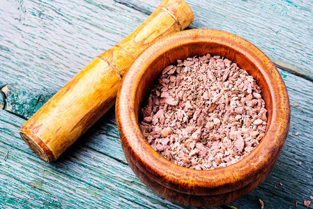 在砂浆中的植物虹膜的研磨根状茎.草药.草药摄影图