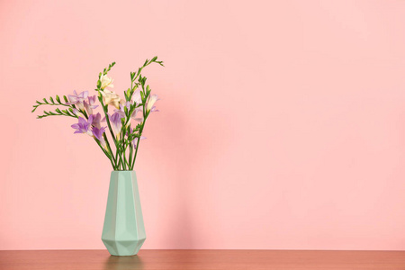 美丽芬芳的小苍兰花在花瓶和空间文本上的颜色背景