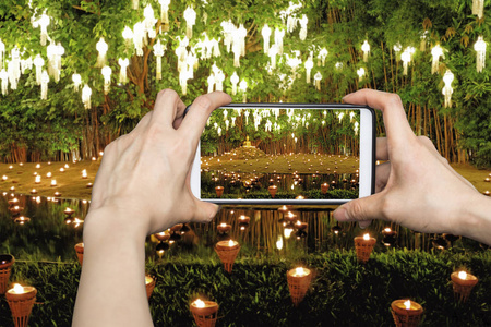 妇女在移动智能手机上拍照显示怡鹏照明劳灯节在泰国清迈的圣陶寺