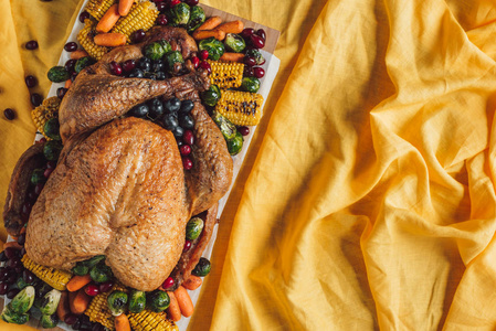餐桌上的烤火鸡和蔬菜的顶级视图黄色桌布, 感恩节假期概念