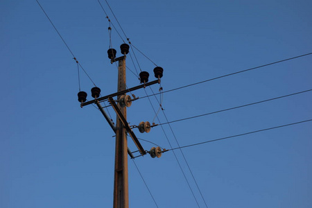 蓝天上的电线杆和电缆照片