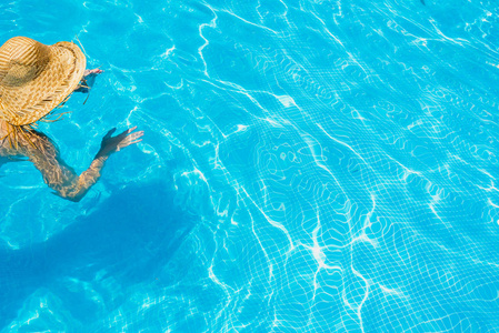 妇女在游泳池与帽子放松和休息