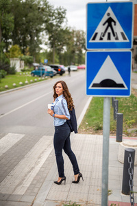 年轻漂亮的女商人在行人过路的街道上过马路