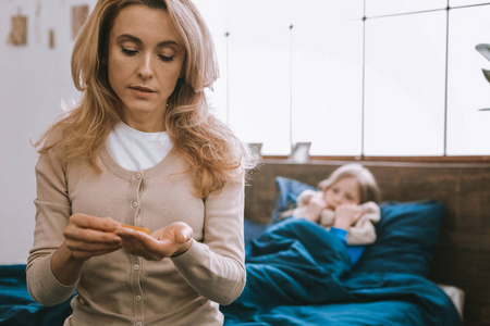 漂亮的金发女人看着药片