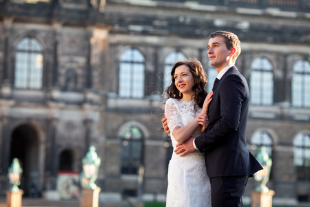 时尚的快乐婚礼情侣背景上美丽文艺复兴时期的古城堡。浪漫新婚的新郎和新娘