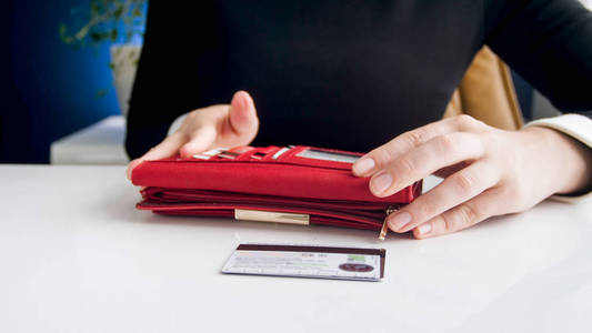 年轻女商人从红色皮夹卡上取出信用卡的特写图像