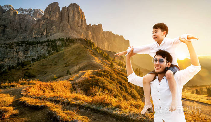 快乐的父亲背着他的儿子在肩上度假和逃离自然