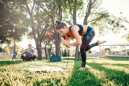 白色白种中年妇女在公园外面做瑜伽在日落。女性伸展身体, 户外锻炼。健康生活方式的现代活动。教练带领体育会议