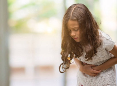 黑发西班牙裔女孩用手在胃因为消化不良, 痛苦的病症感觉不适.