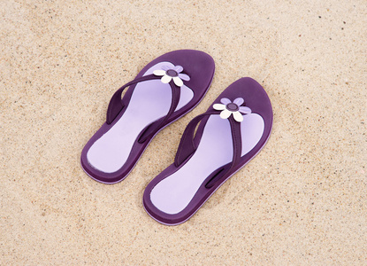 海滩上漂亮的紫色拖鞋