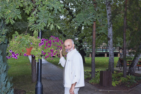 一个成熟的人, 在公园里挂着一盏灯柱的花。