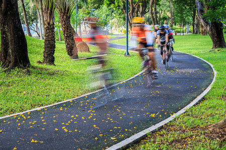 速度在公园里的自行车道上骑自行车的人