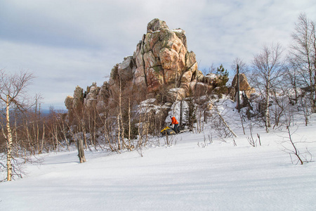 运动员骑乘雪车在乌拉尔山脉南部山区冬季森林中移动